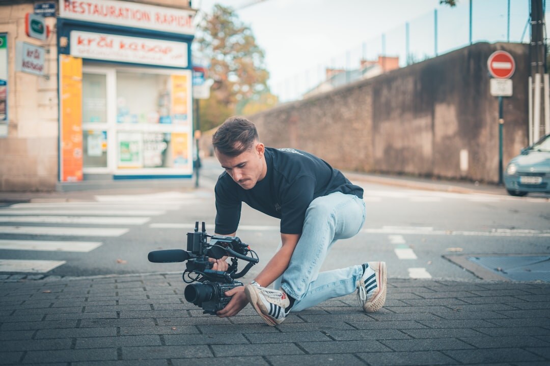 Photojournalist crouching to photograph a street scene during a news event