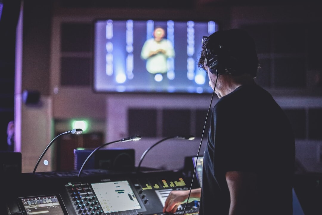 Producer coordinating a live broadcast from a control room with multiple screens
