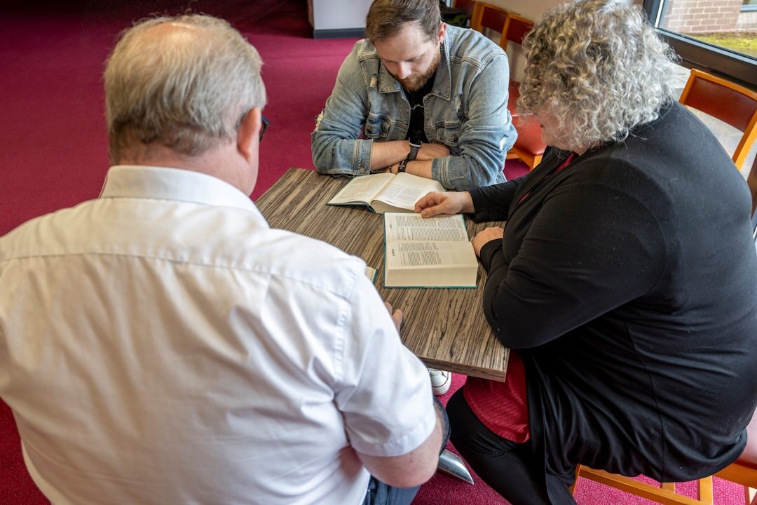 Small team of trainers gathered around a table reviewing a course curriculum